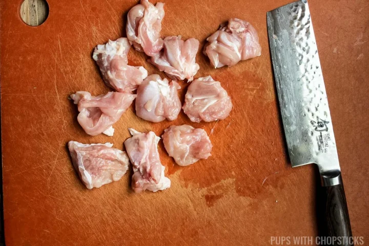 Cutting chicken into bite sized pieces.
