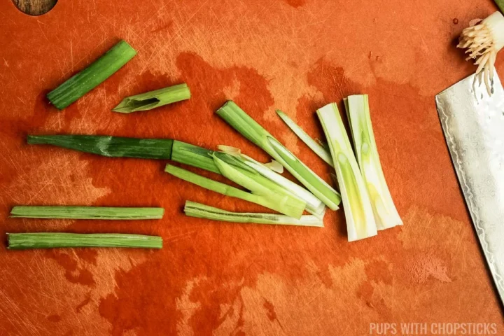 Cutting green onions length wise in 2 inch chunks.