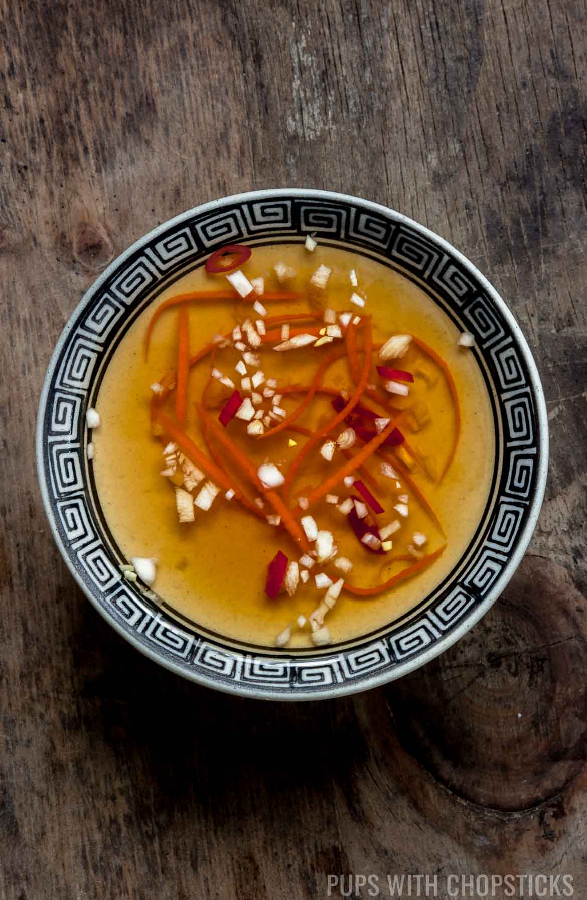 Vietnamese Dipping Sauce (Nuoc Cham / Nuoc Mam) in a small bowl on a wooden table