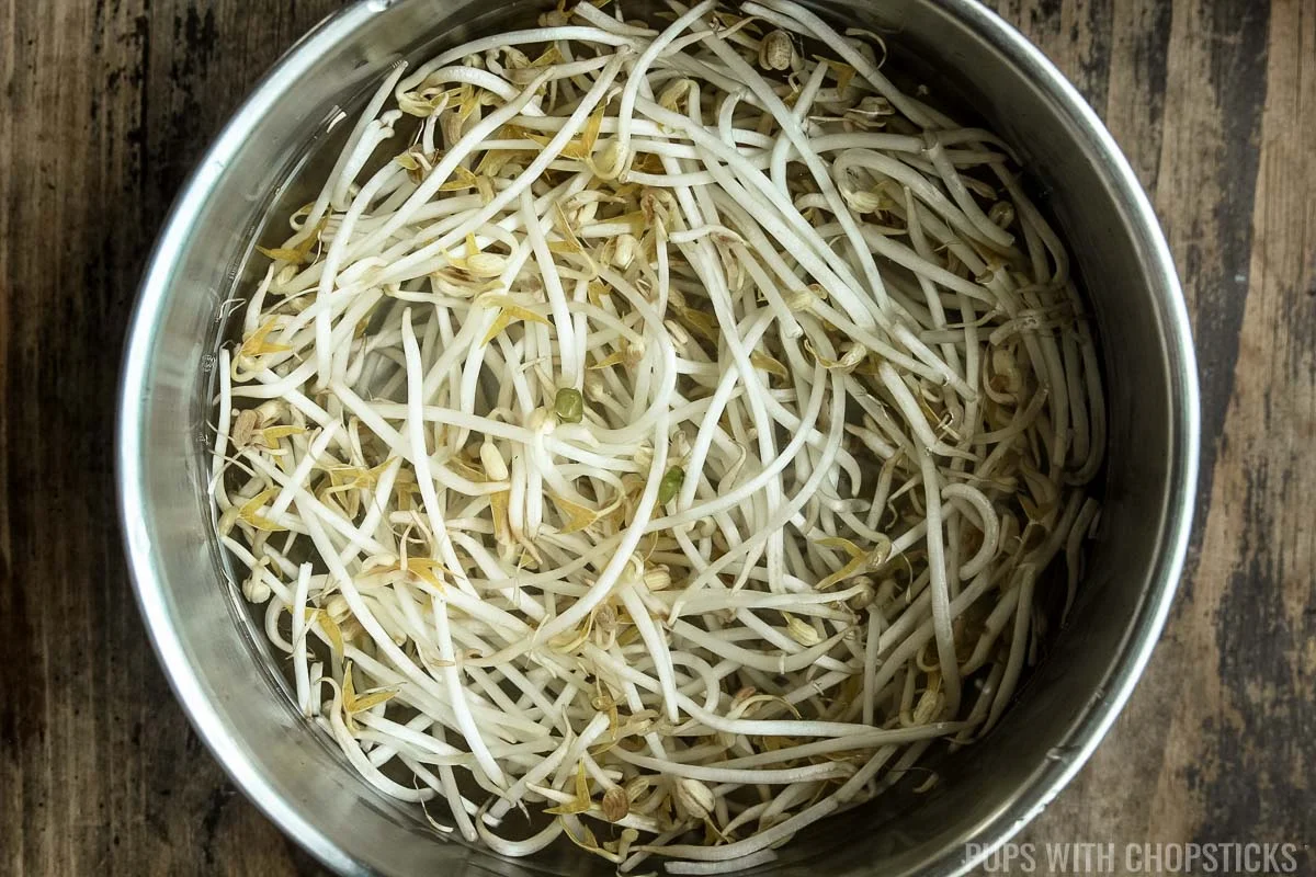 Bean sprouts being cleaned by soaking it in cold water.