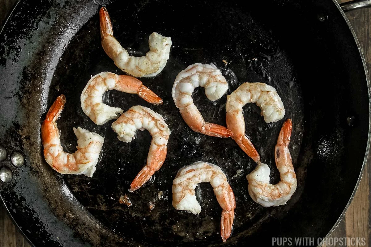 Shrimp being pan fried in a frying pan.