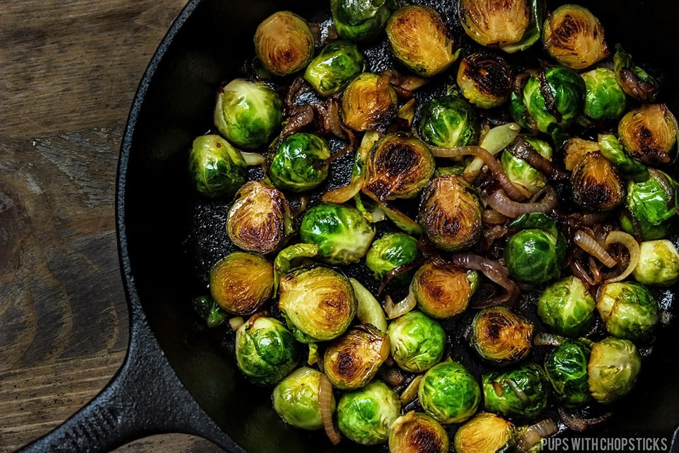 Honey Glazed Pan Fried Brussels Sprouts in a cast iron pan with dark charring