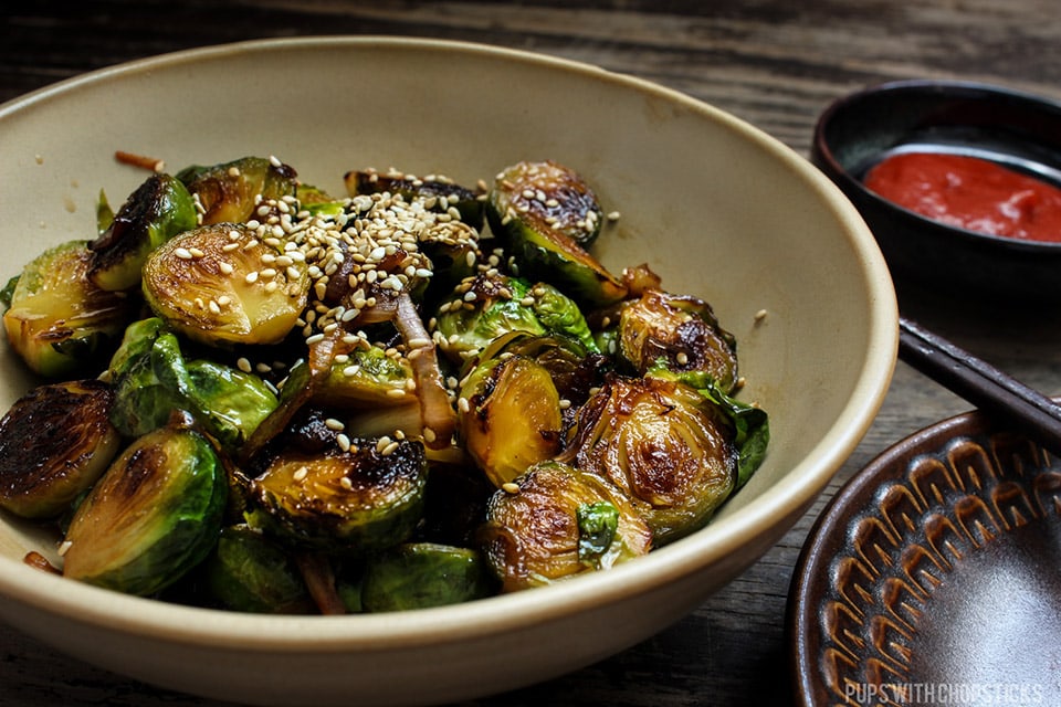 Honey Glazed Pan Fried Brussels Sprouts in a large bowl sprinkled with sesame seeds on top