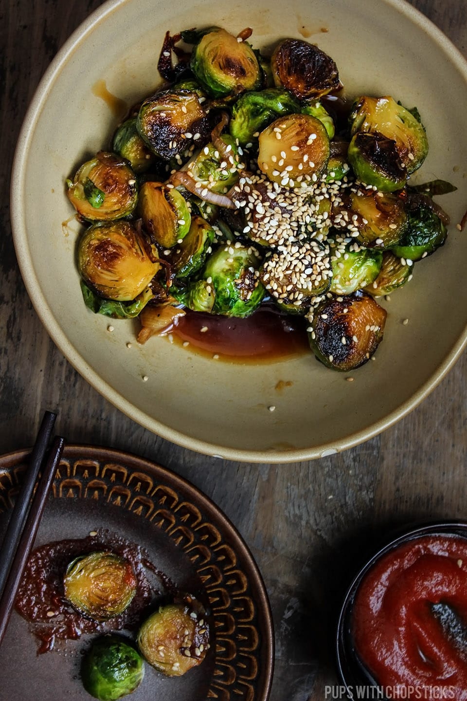 Honey Glazed Pan Fried Brussels Sprouts topped with sesame seeds and served in a large bowl