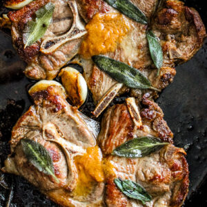 Closeup of miso butter pan fried lamb shoulder chops with garlic and sage