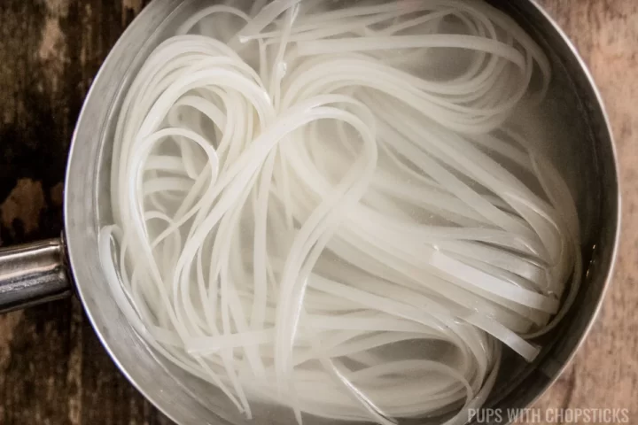 Boiling rice noodles in a pot of boiling water