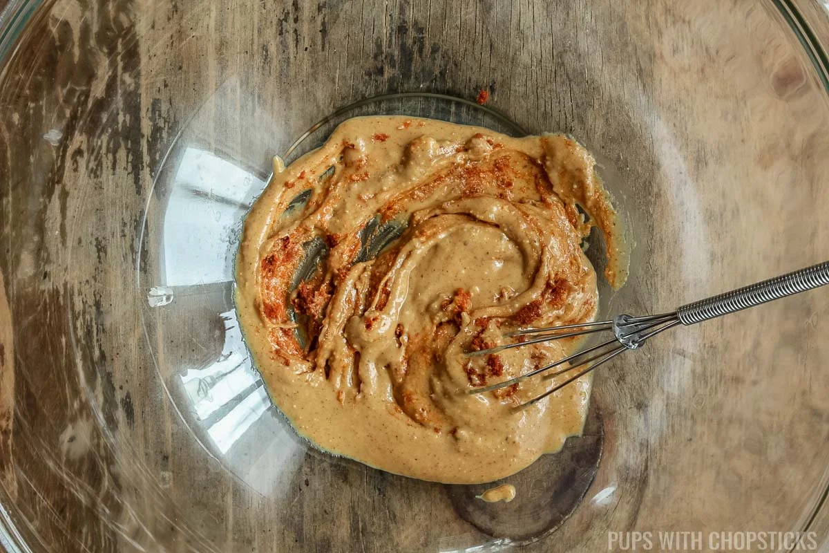 Mixing peanut butter and red curry paste for thai peanut noodle sauce
