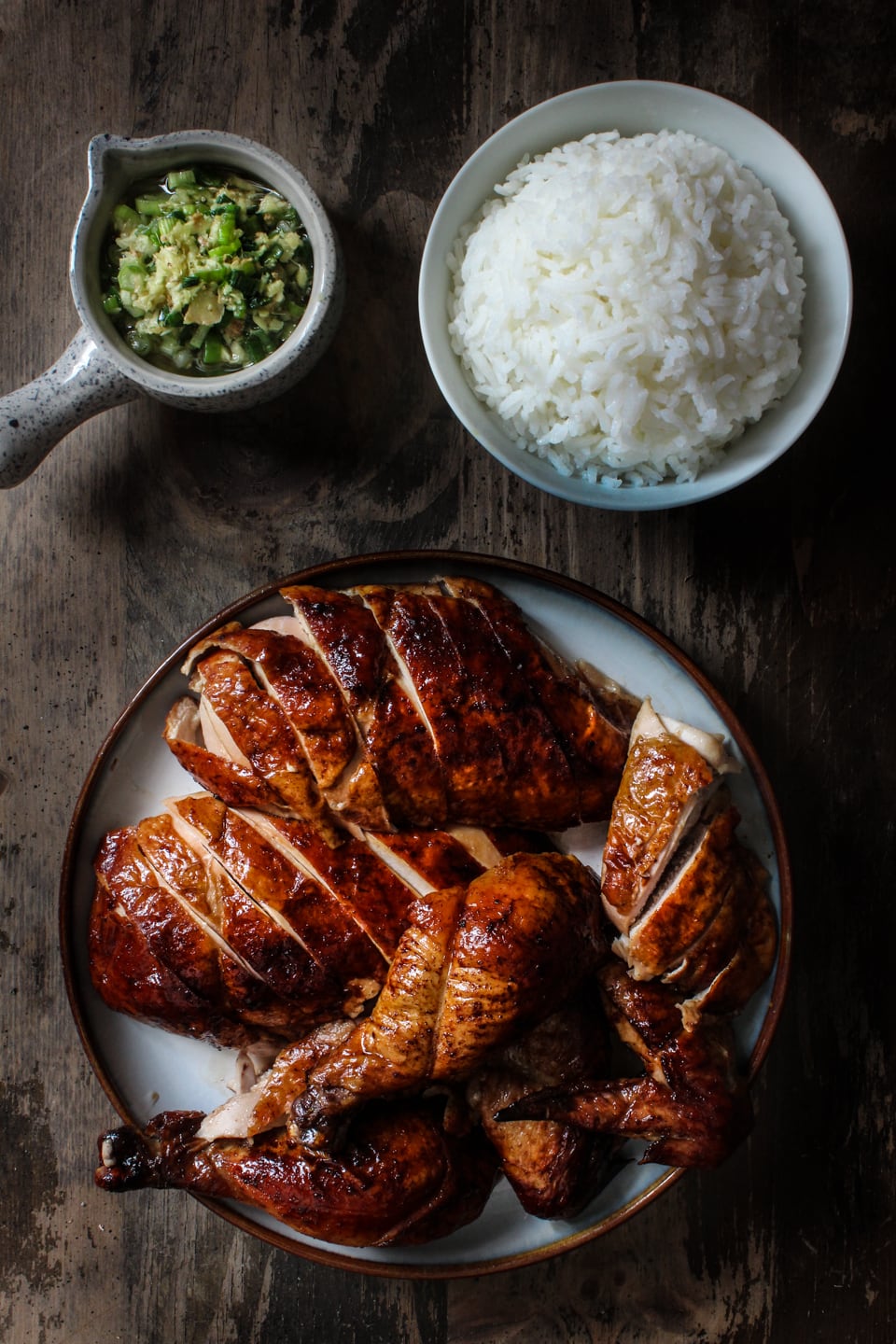 Peking-Huhn serviert mit einer Schüssel Reis und Ingwer-Schalotten-Sauce