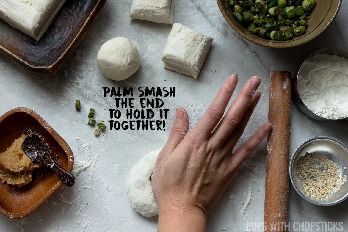 Rolling out Scallion Pancakes - Step 4, using your palm, smash the pancake down where the end is tucked to hold it together