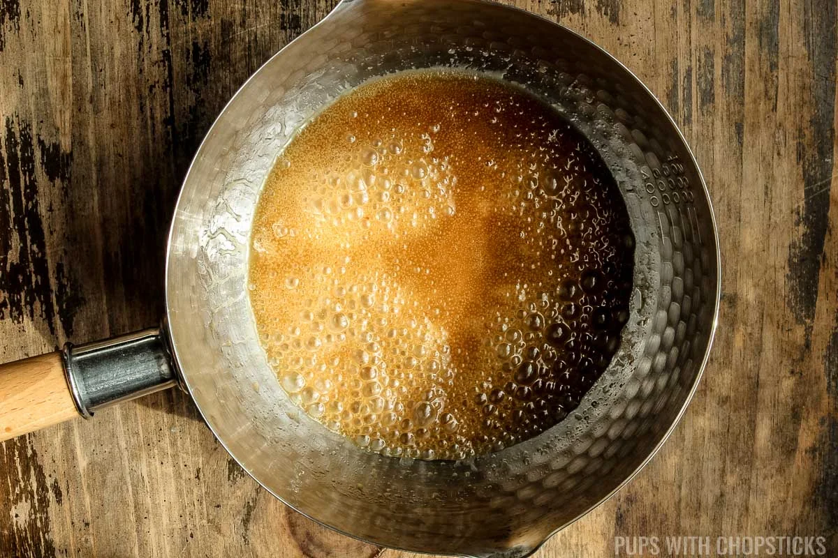 Small pot with honey and sugar melted into the butter 