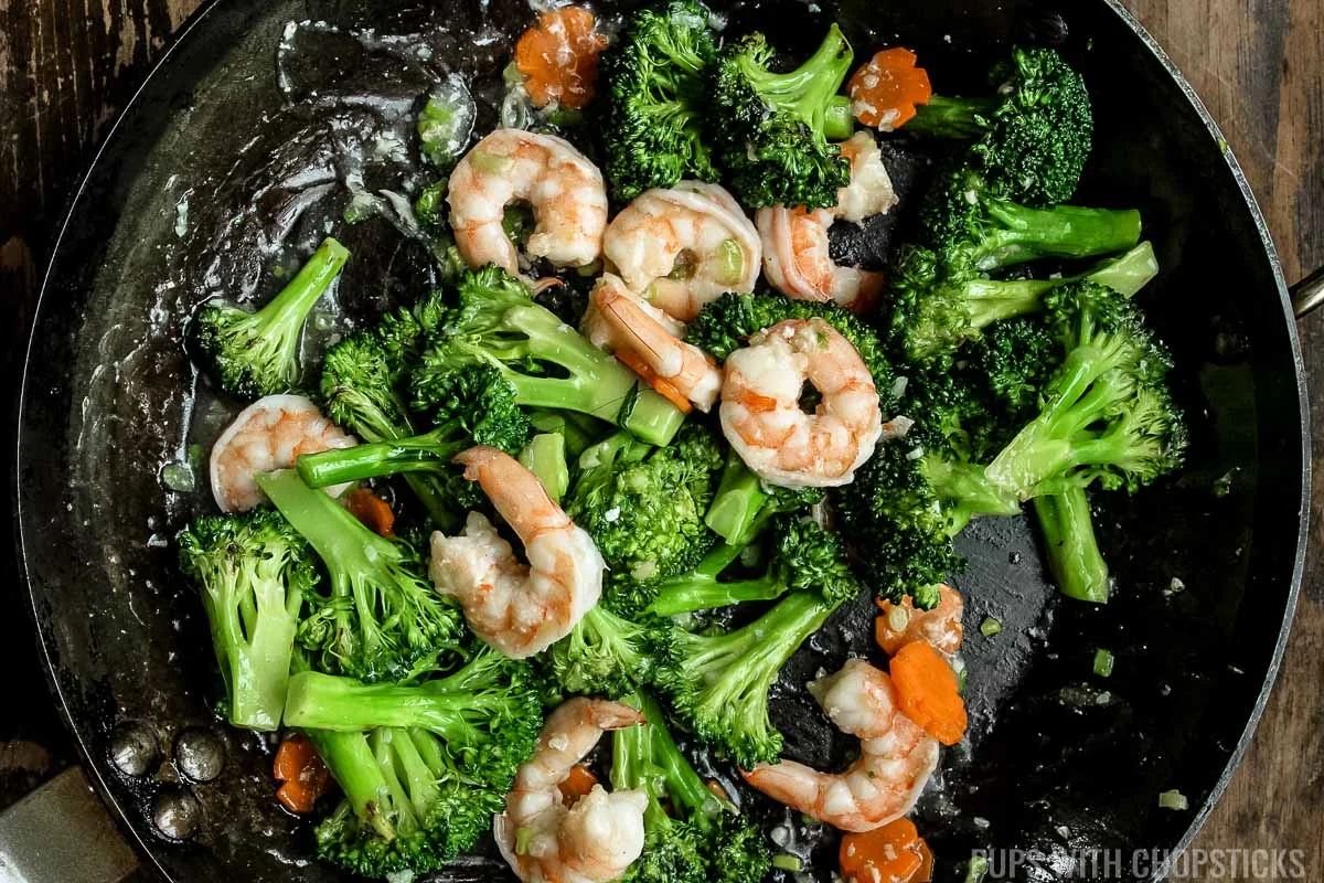 Mix broccoli and shrimp together with white sauce in pan.