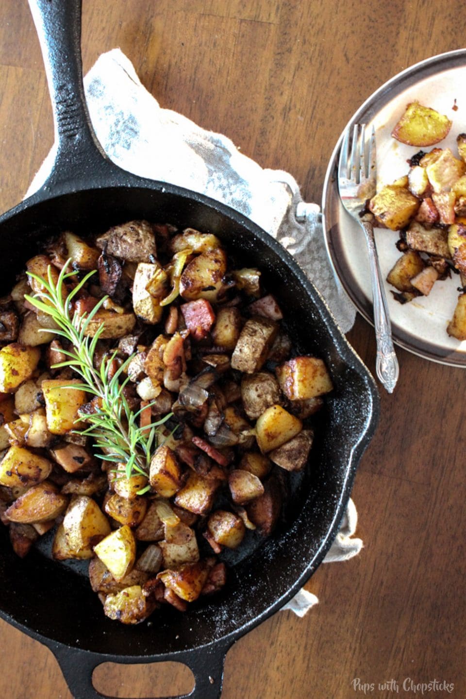 Skillet Potatoes Infused with Caramelized Onions in an cast iron pan with a heaping of potatoes on a plate