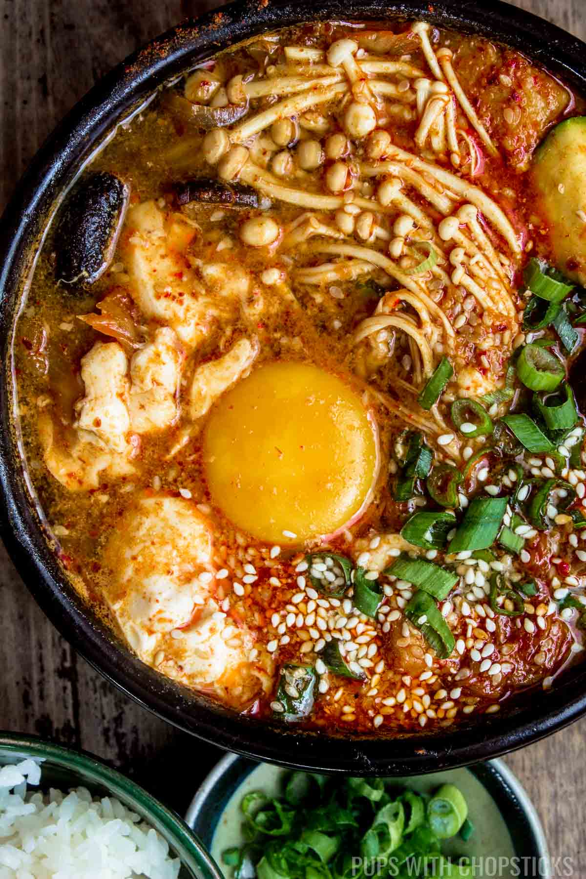 A large bowl of spicy kimchi tofu stew (Soondubu Jjigae) with an egg