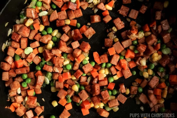 Softening frozen veggies with spam in frying pan