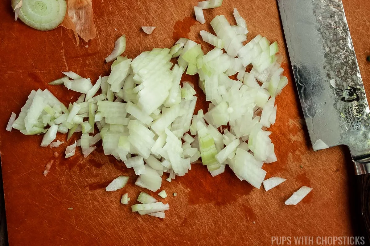 Finely diced onions on a cutting board.