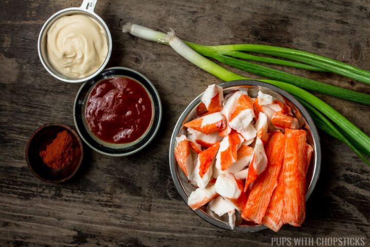 Ingredients for sushi-style crab dip (mayonnaise, cayenne, sriracha, green onions, imitation crab meat)