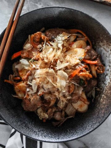 A large bowl of stir fried rice cake with kimchi