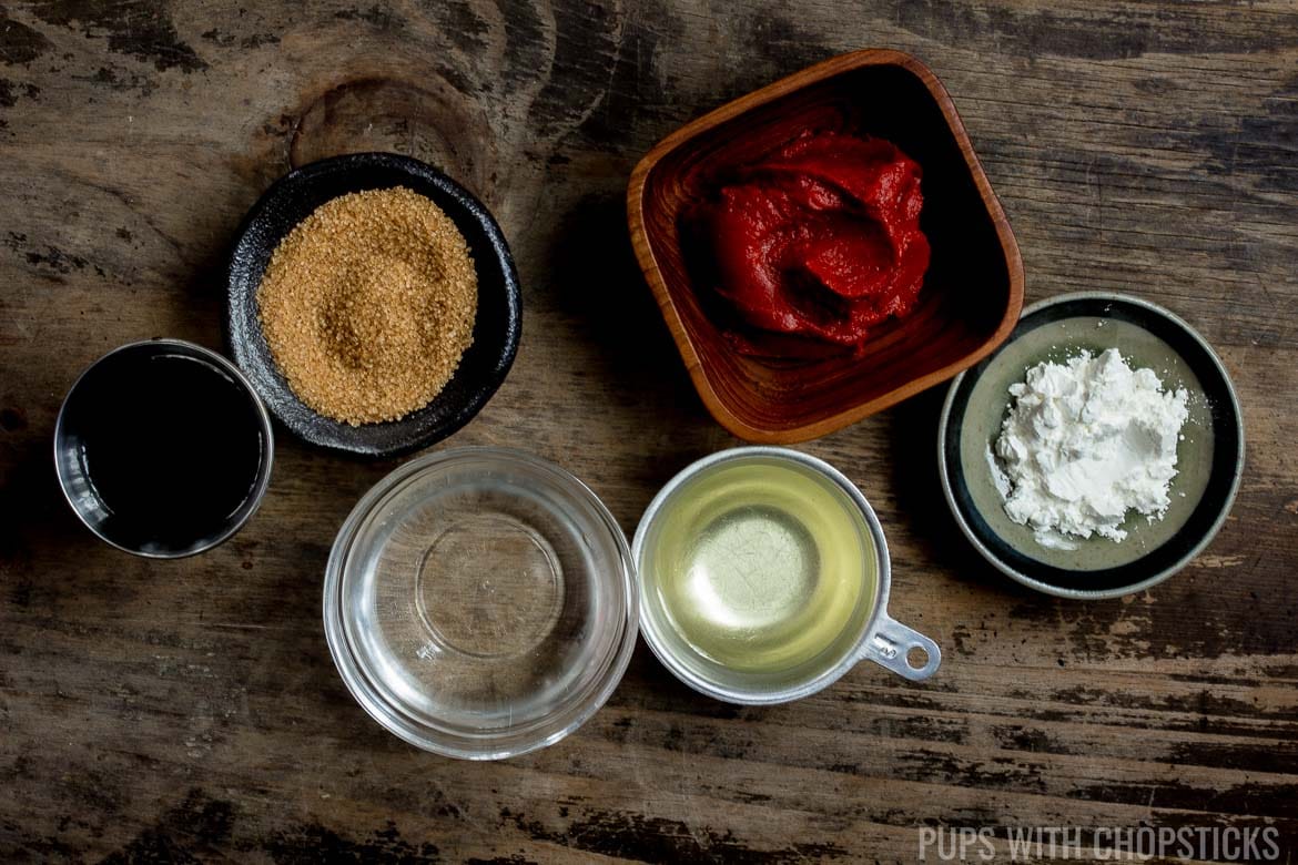 Sweet and sour sauce ingredients for Sweet and Sour Pork laid out in bowls on a wooden table