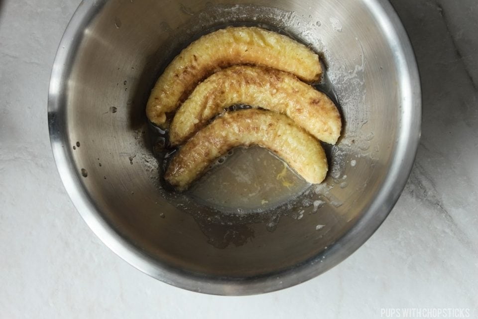 Oven roasted bananas peeled into a bowl with banana skins squeezed for extra banana extract liquids