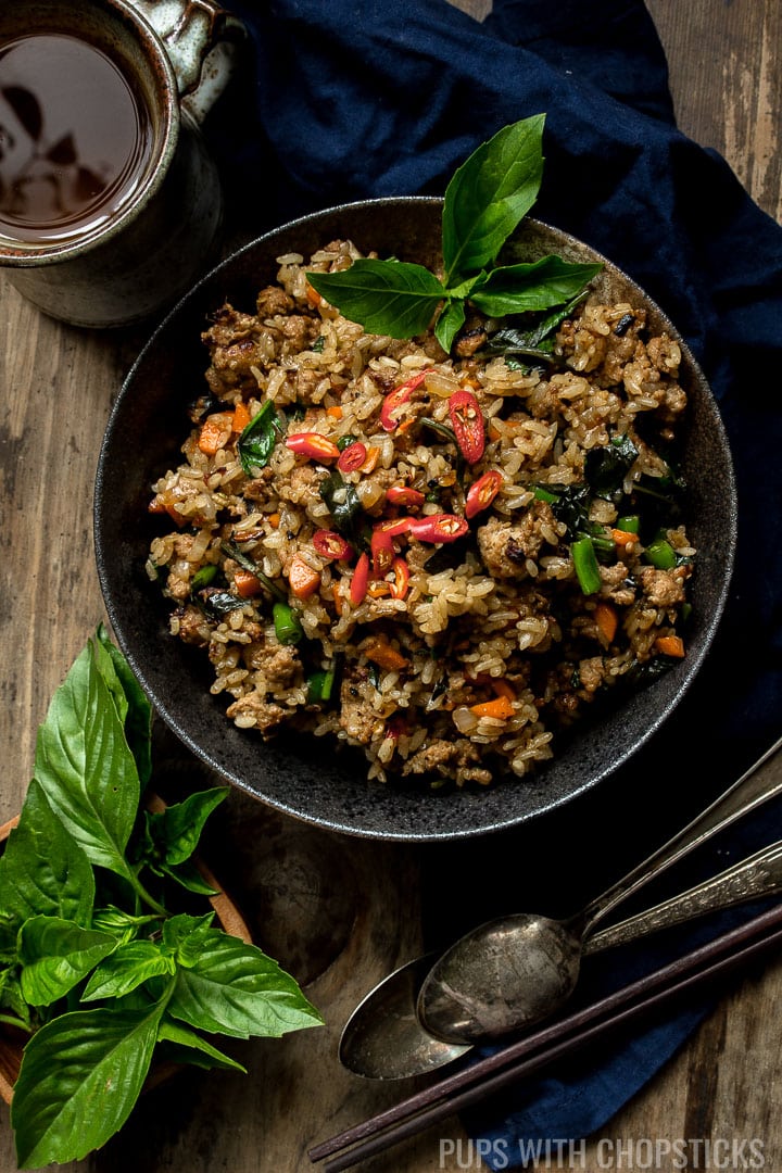 A large bowl of Thai Basil Turkey fried rice with a cup of tea on the side.