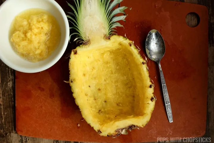 clean out pineapple bowl by scooping fruit and juice out.