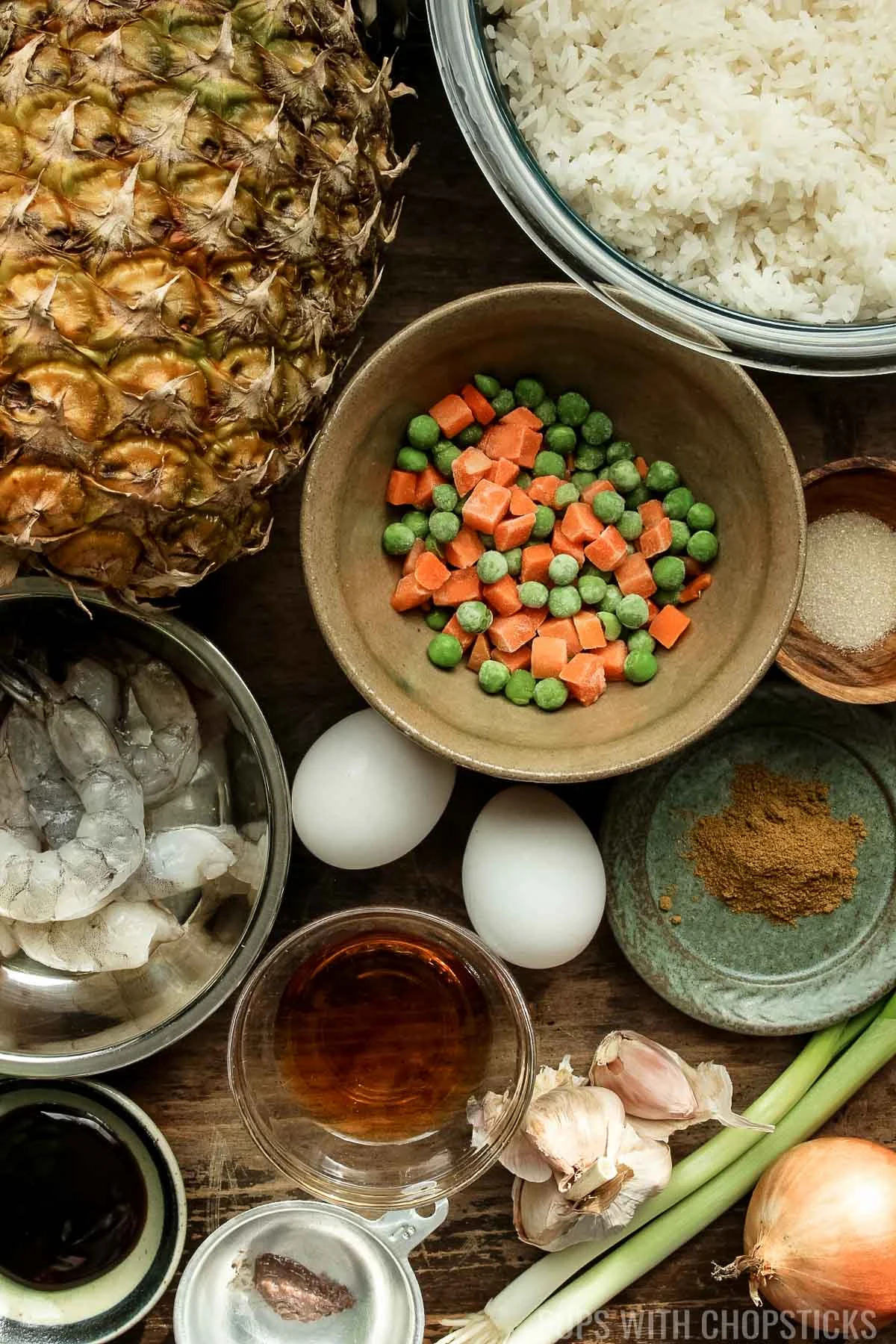 thai pineapple rice ingredients (curry powder, fish sauce, shrimp, frozen veg, rice, pineapple, eggs, garlic, onions)