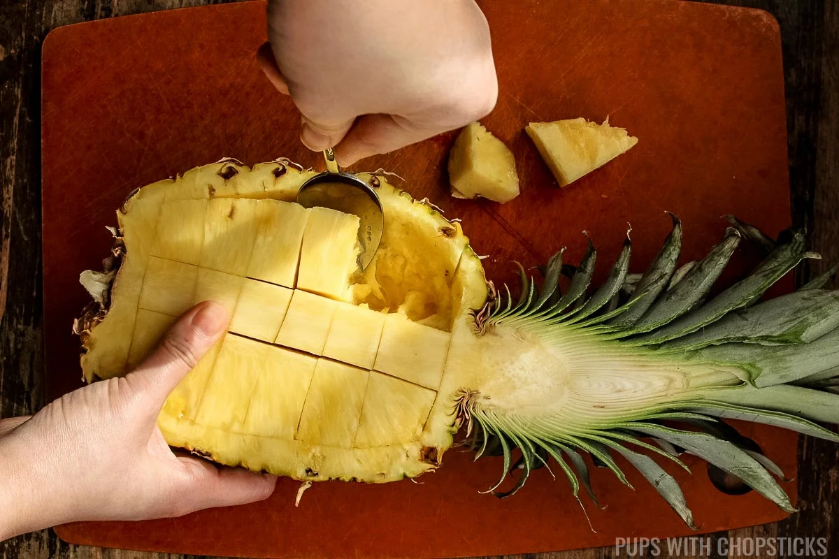 scooping pineapple pieces out with a spoon