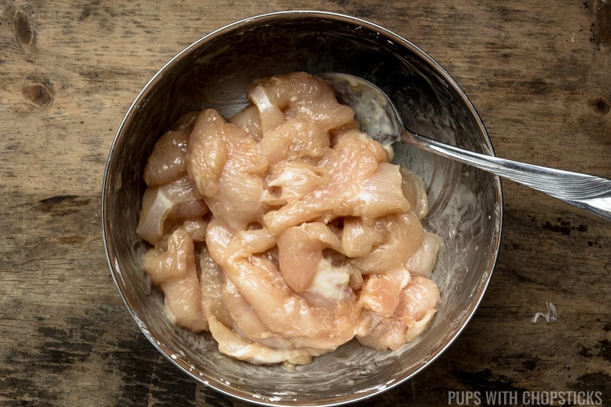 Thinly sliced chicken breast being marinated