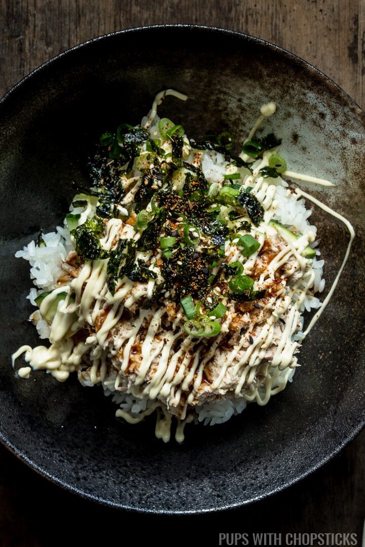 A close up of tuna mayo (deopbap) on a bed of rice topped with mayonnaise, green onions and sweet soy
