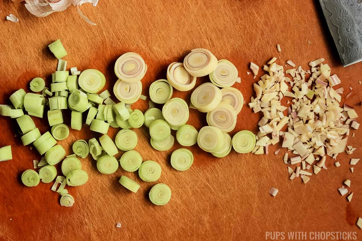 Closeup of lemongrass on a cutting board being finely chopped.
