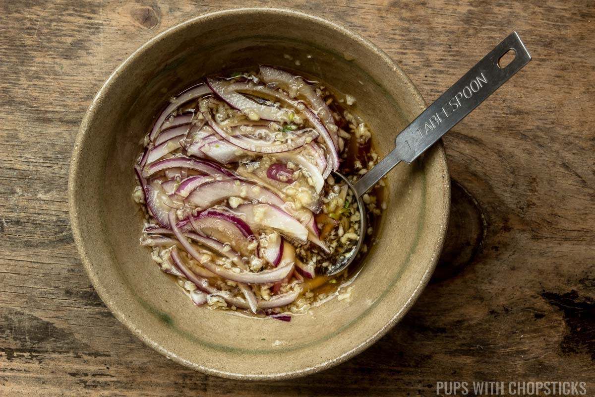 A small bowl of fish sauce dressing with red onions mixed in to remove the spiciness of onions
