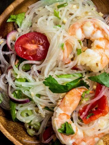Close up of yum woon sen noodle salad with shrimp and glass noodles on a wooden plate